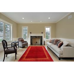Červený vlnený koberec v béžovej obývačke.