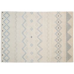 Krémovo šedý vlnený koberec s modrým geometrickým motívom.