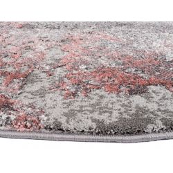 Detail obšitia kruhového koberca s hustým vlasom v šedo ružovej farbe.